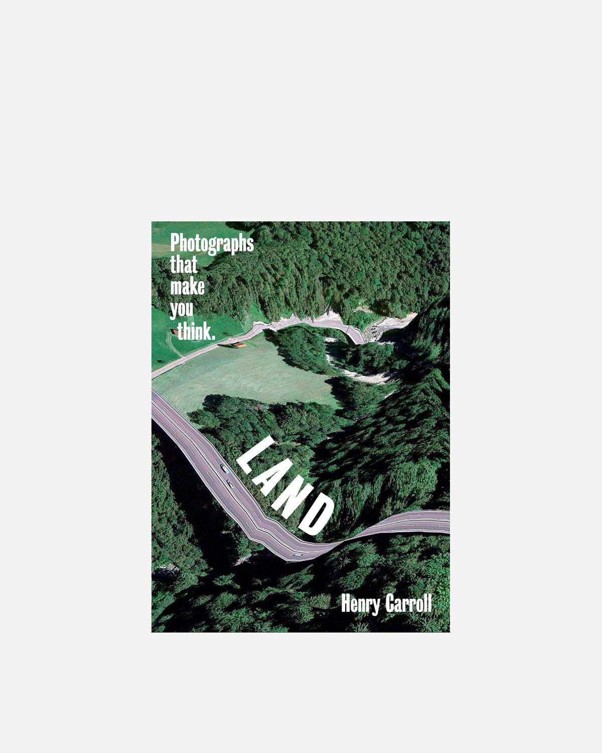 Book cover for 'Land: Photographs that make you think.' by Henry Carroll, featuring an aerial view of a winding road through dense green forest and a grassy field.