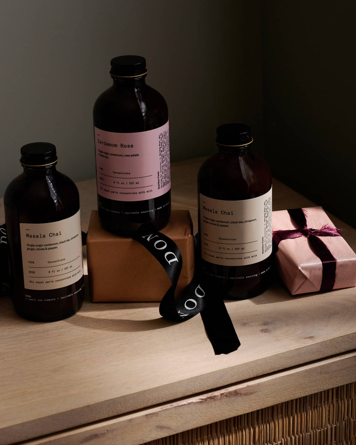 DONA chai concentrate bottles arranged with wrapped gifts